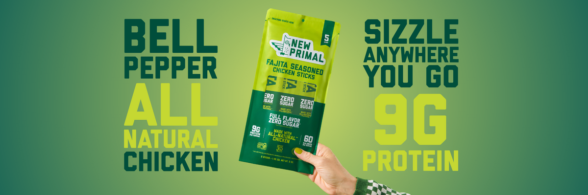 A hand holds a 5-count bag of New Primal Fajita Seasoned Chicken Sticks. Text reads: bell pepper, all-natural chicken, sizzle anywhere you go, 9g protein.