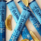 5 classic beef sticks on a white ground with lemon wedges and salt around them